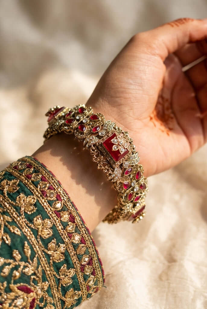 Royal ruby kundan bridal bangle - Pakistani women's luxury bridal jewelry with deep ruby stones and crystal accents in gold tone front view
