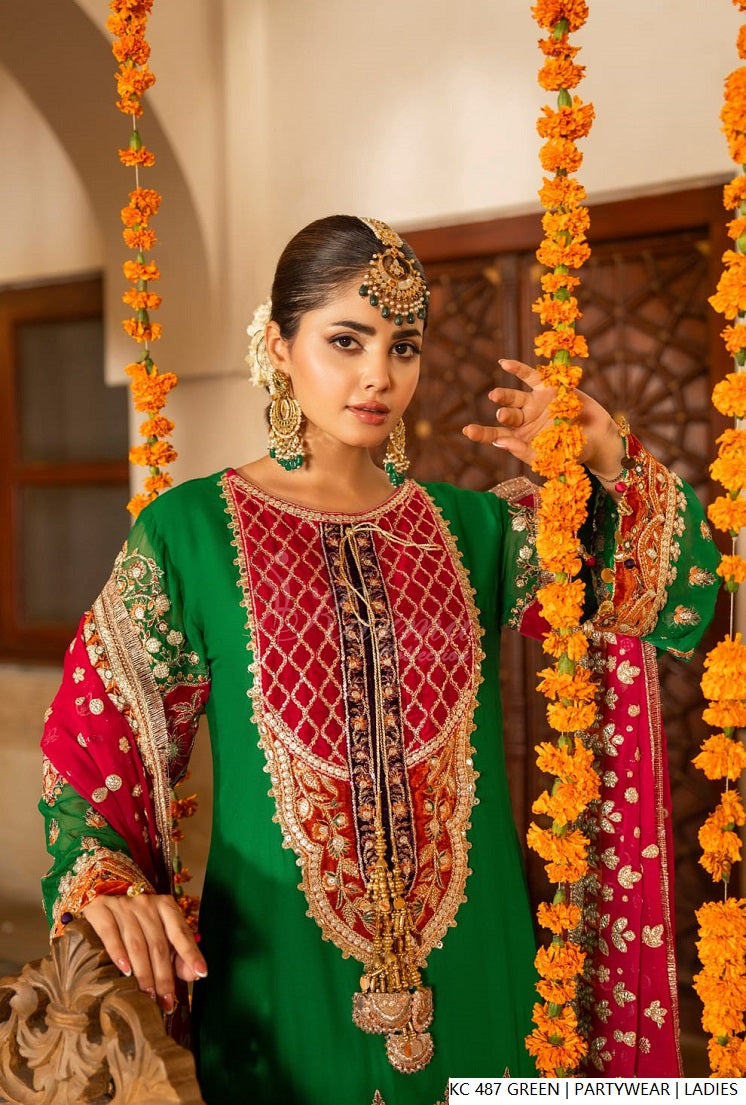 Karma Collection Pakistan model wearing elegant green partywear outfit with intricate detailing and traditional aesthetics.