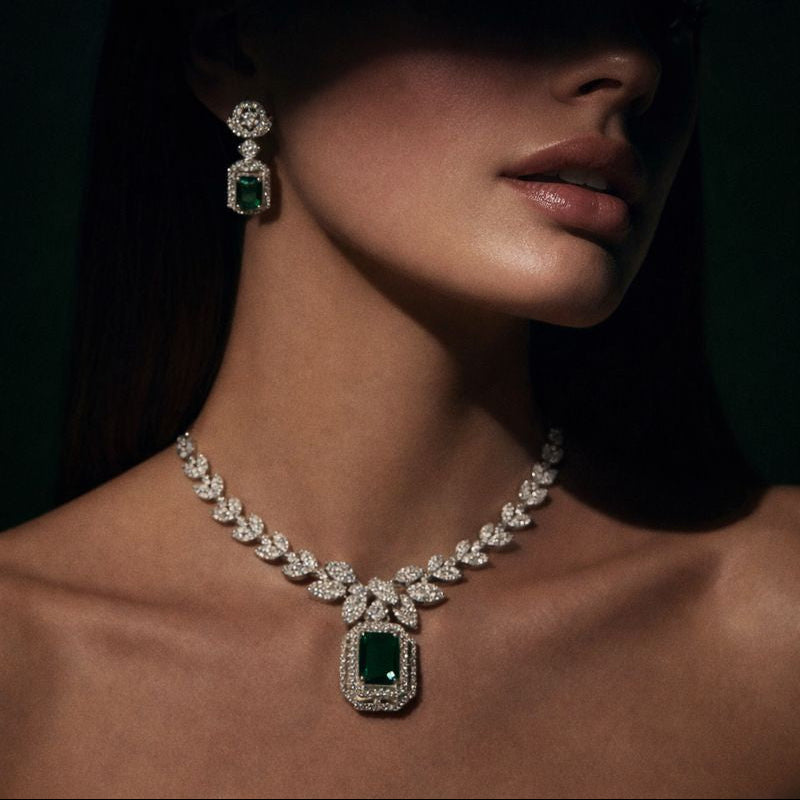 Gold Plated Stud Earrings displayed elegantly with a model wearing a sophisticated emerald and diamond necklace.