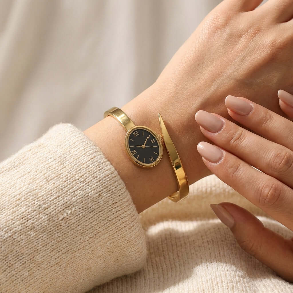 Minimal gold watch bangle - Pakistani women's elegant jewelry with oval black dial and Roman numerals in slim gold tone front view
