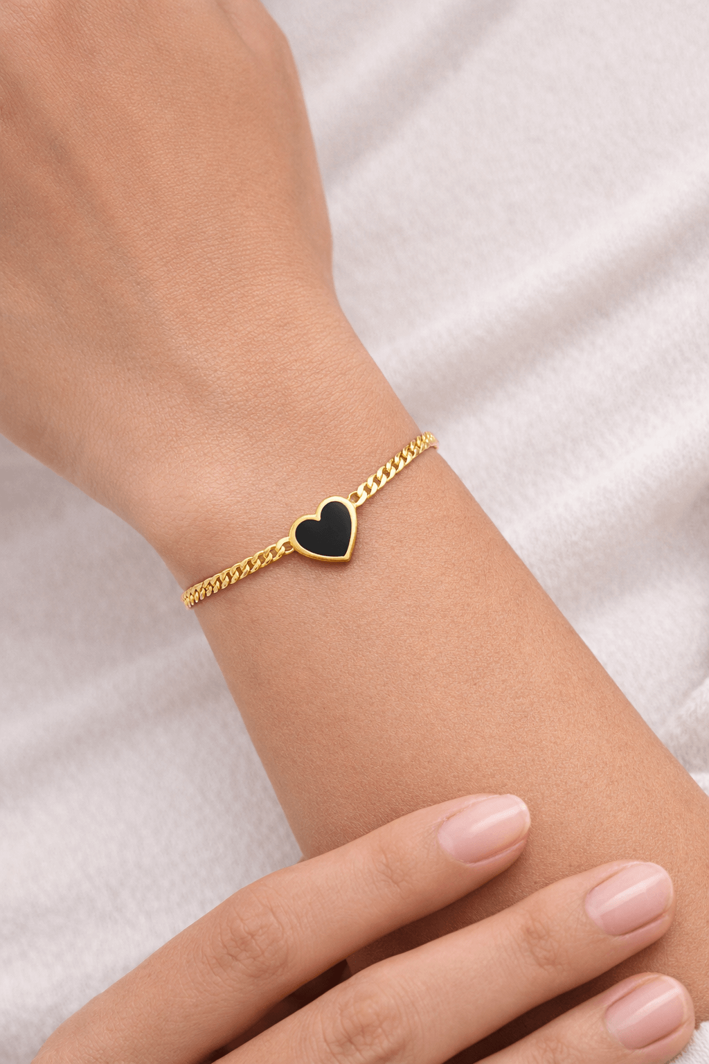 Black heart gold bracelet - Pakistani women's elegant jewelry with gold tone chain and bold black heart charm front view